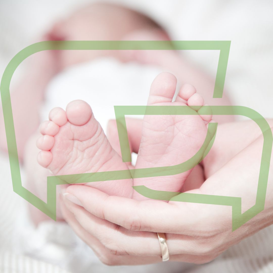 Babyfüsse in der Hand von einem Erwachsenen